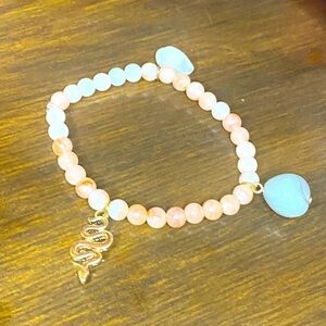 Natural pink stone beaded bracelet with three charms